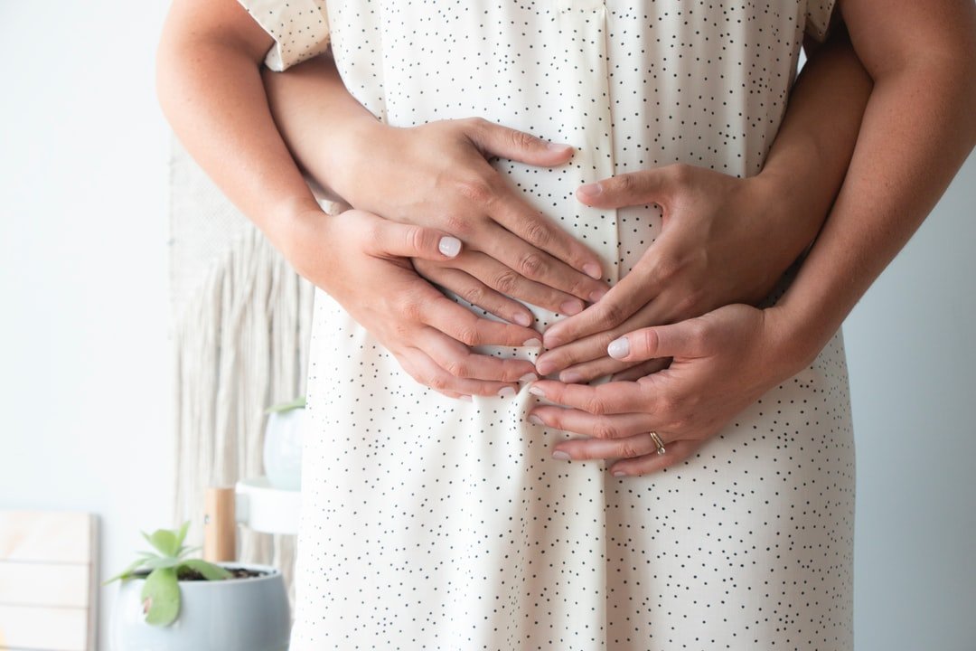 Femme enceinte et son conjoint qui touchent le ventre