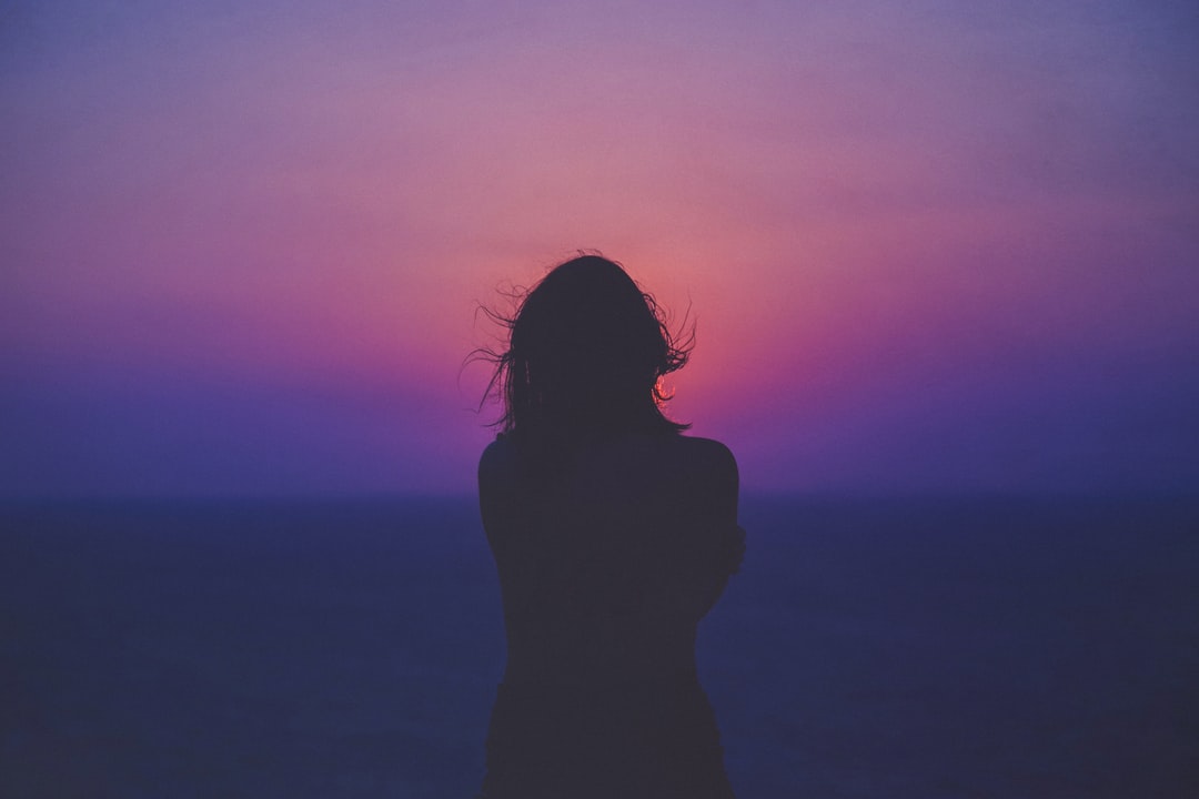Femme devant un coucher de soleil